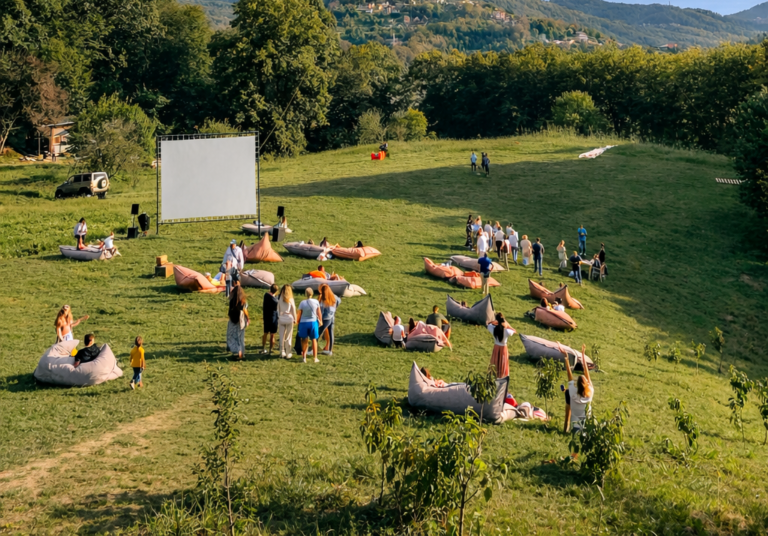 Outdoor luxury picnic experience with guests relaxing on bean bags in a scenic green hillside setting